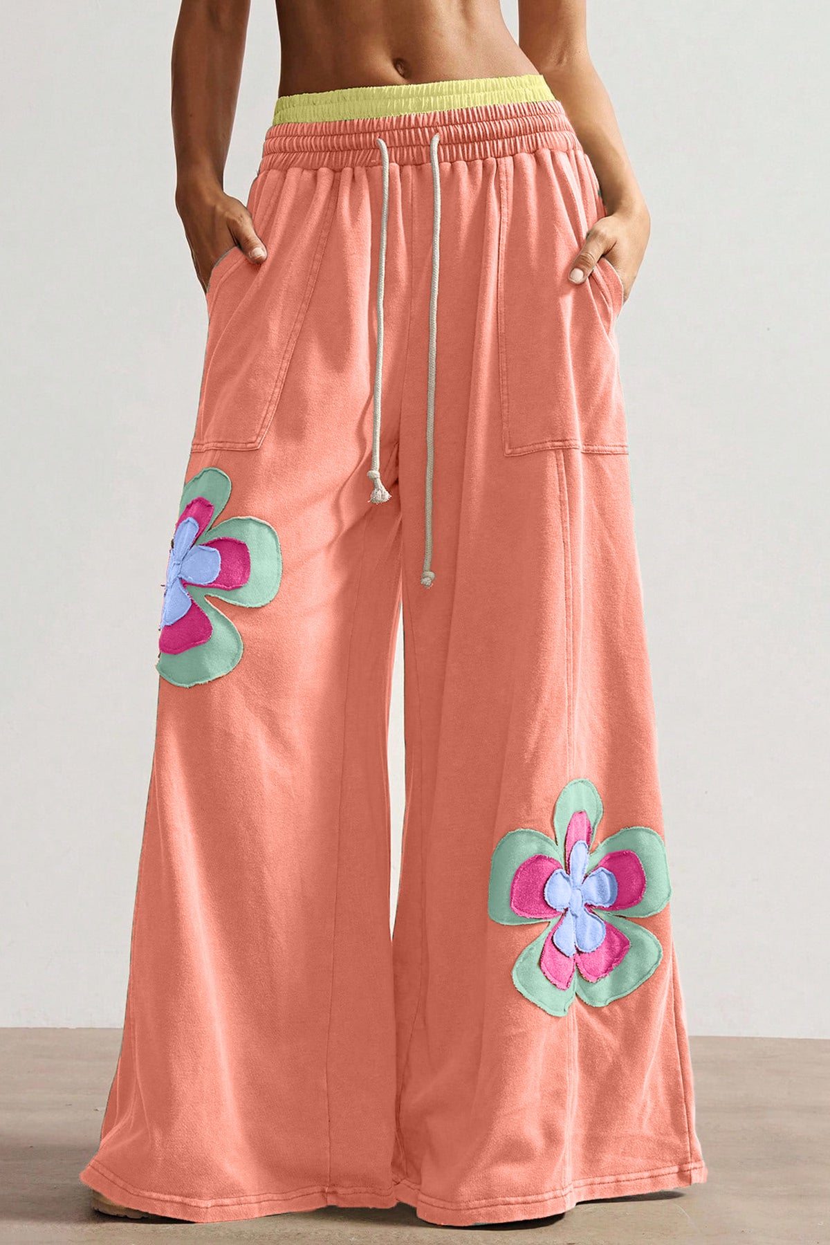 Pantalon ample corail à fleurs appliquées, taille élastique avec cordon, jambes larges.