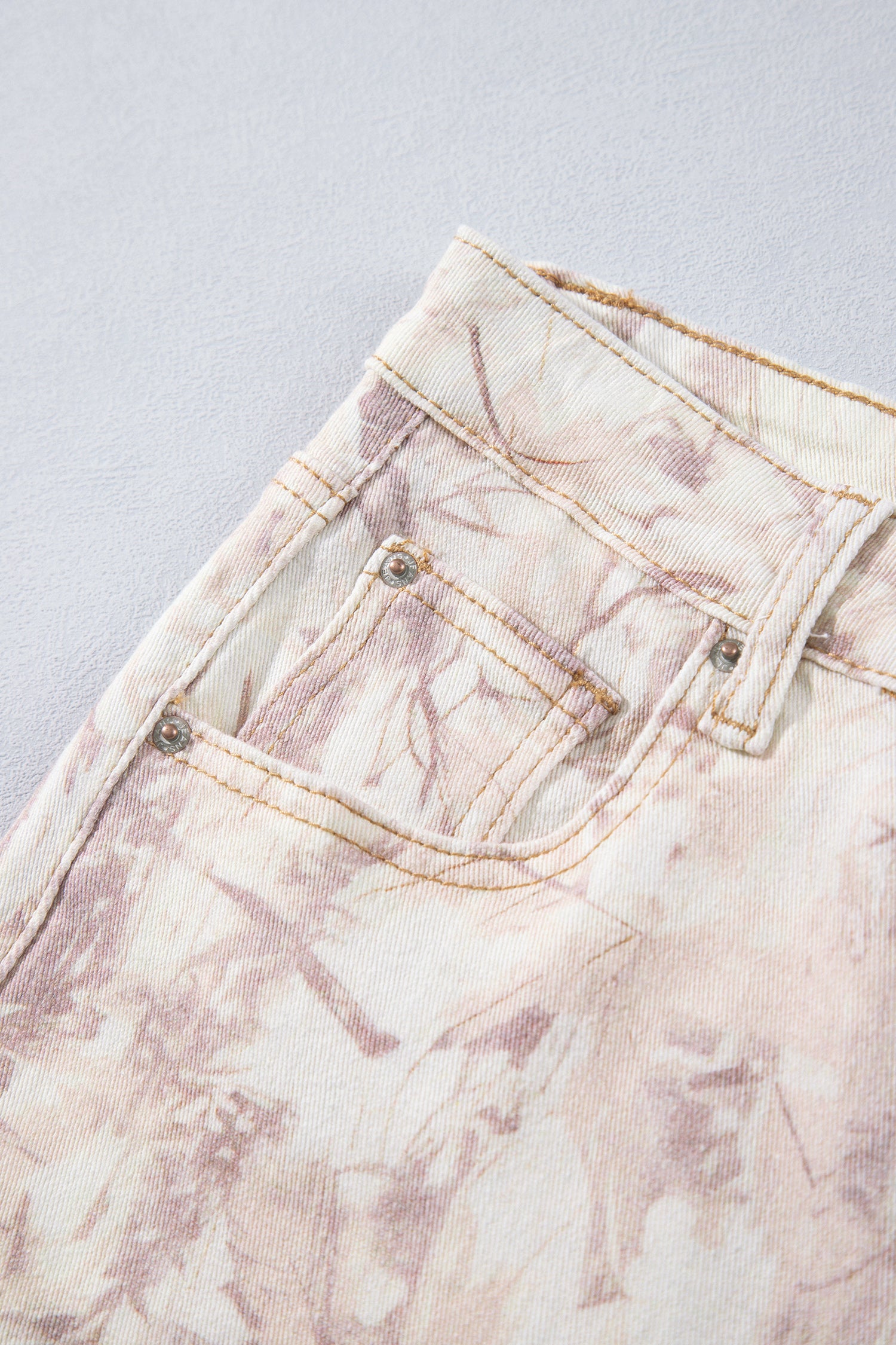 Jean large femme motif camouflage rose clair, poche avant et couture de taille.