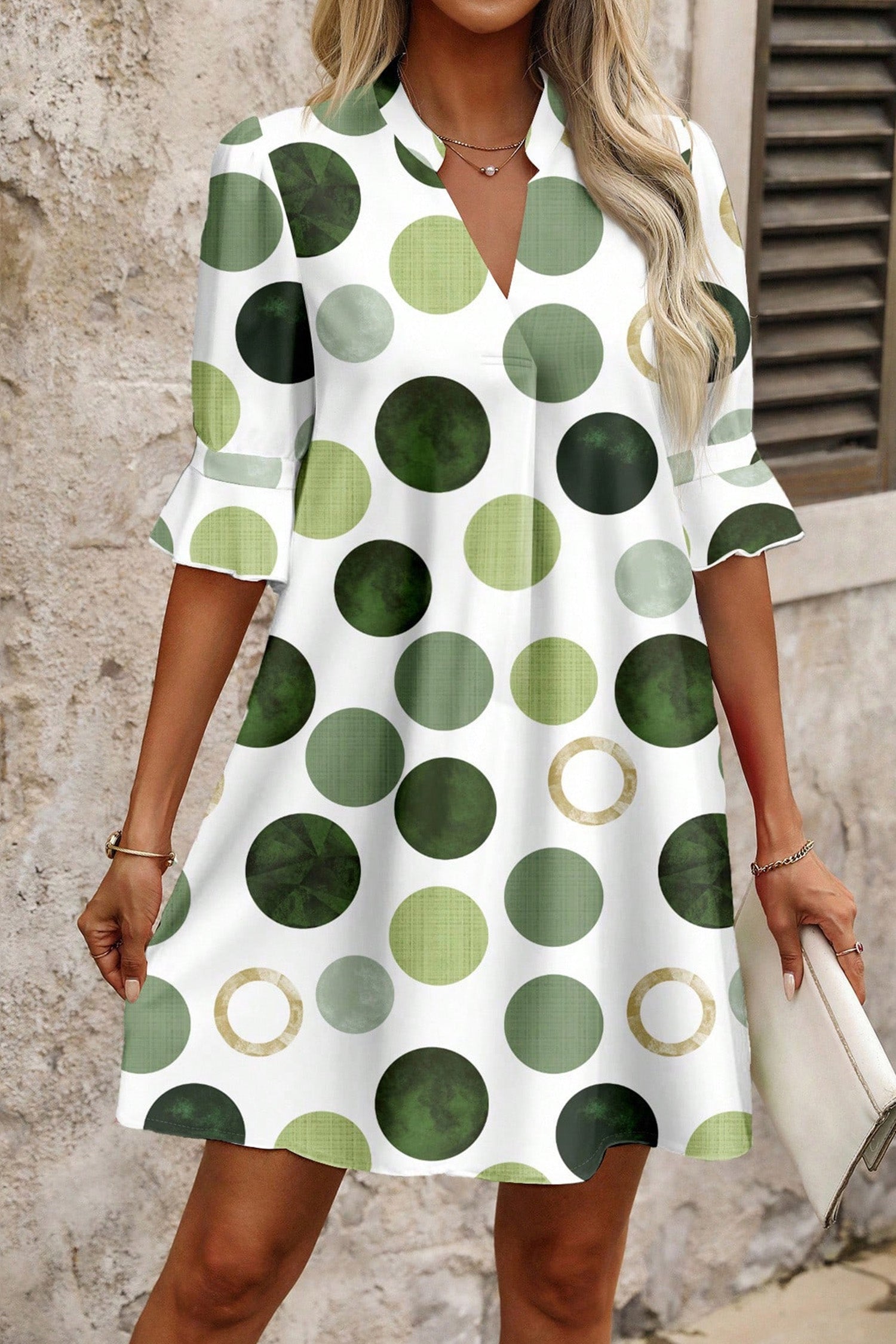 Robe mini à pois verts et ronds beiges, col V, manches évasées, coupe droite.