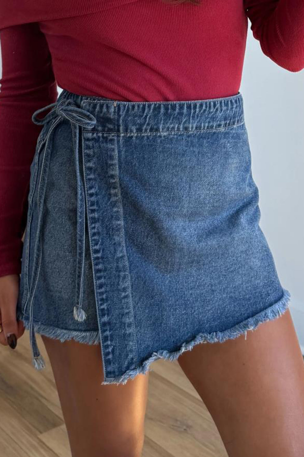 Short en jean bleu à ceinture nouée devant et ourlet effiloché