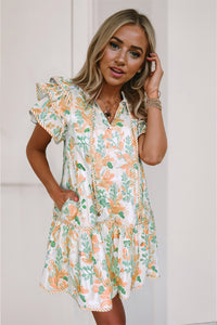 Robe courte à motifs végétaux orange et verts, manches volantées, col V, volant bas.