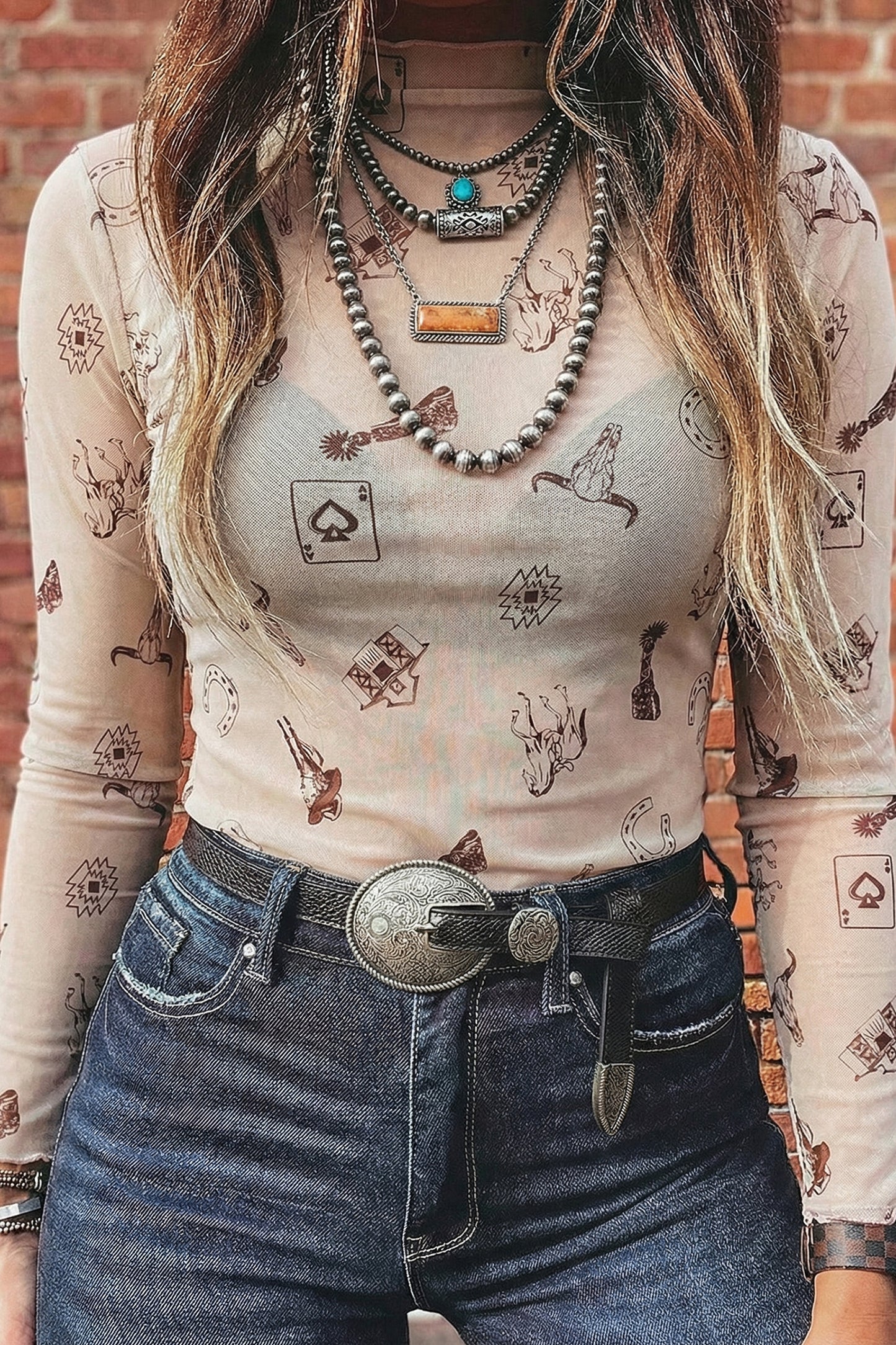 Haut femme manches longues en maille beige, imprimé à motifs, col près du cou.