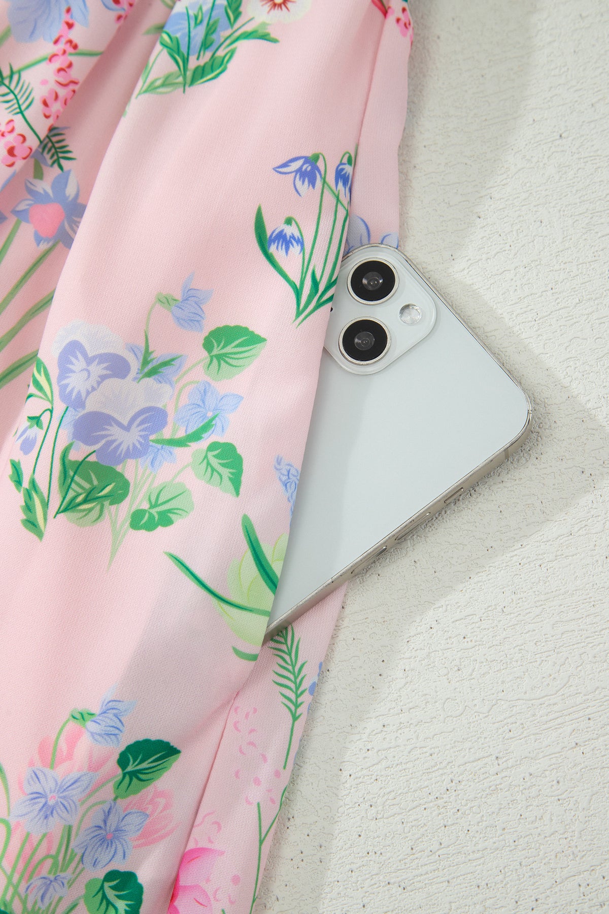 Robe rose imprimée fleurs et feuillages, bretelles fines, bord bleu.