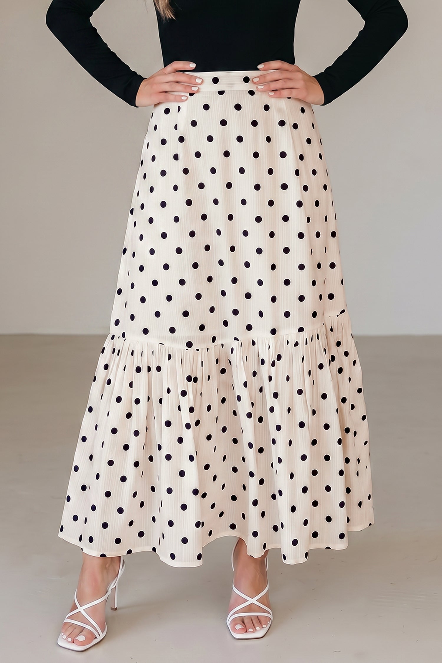 Jupe longue blanche à pois noirs, volants en étages et ceinture froncée