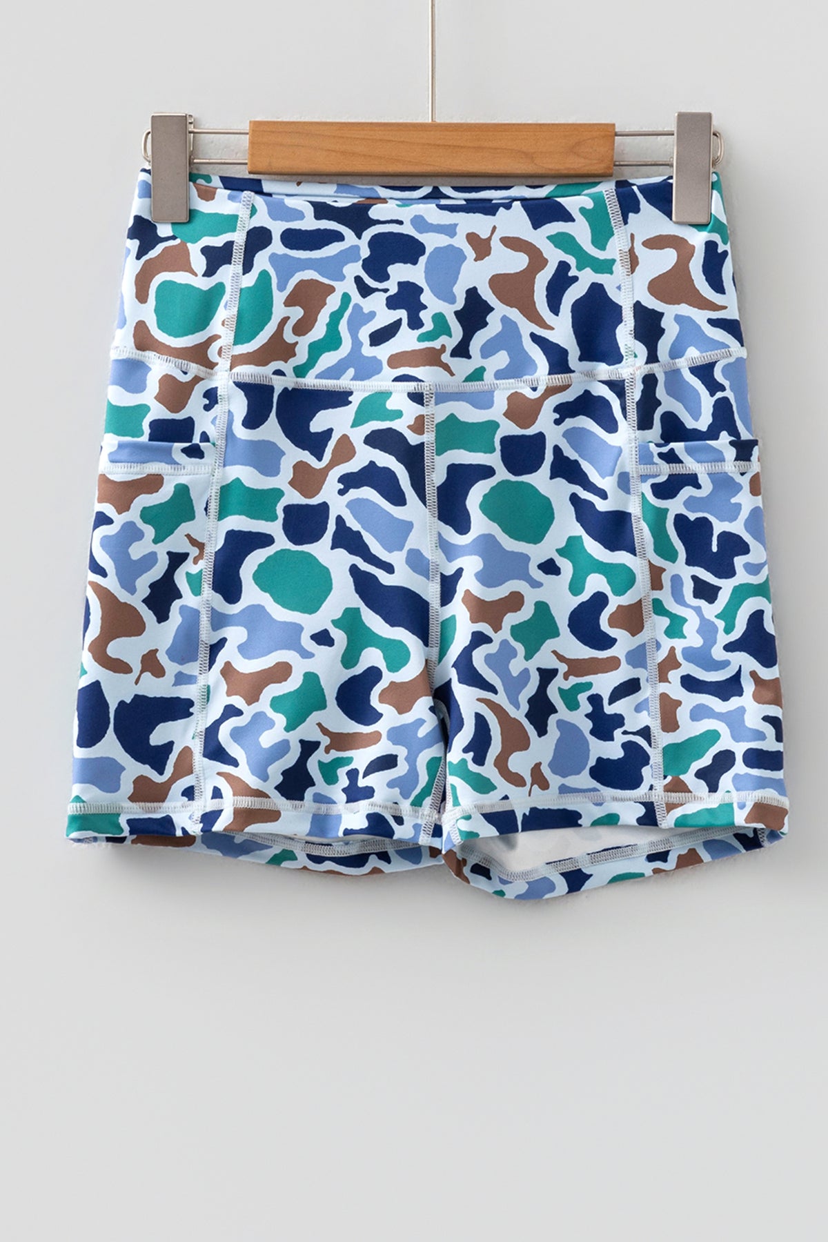 Short cycliste imprimé camouflage bleu et multicolore, taille élastique, coupe courte.