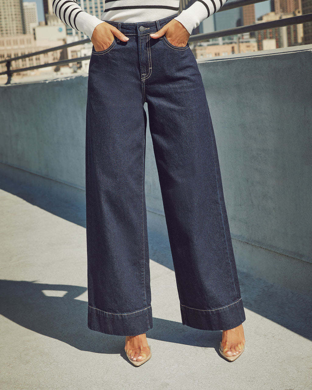 Jean taille haute bleu marine, jambe ample, passants de ceinture, coutures contrastées