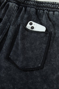 Détail pantalon noir délavé minéral : poche plaquée, taille élastique, cordon de serrage
