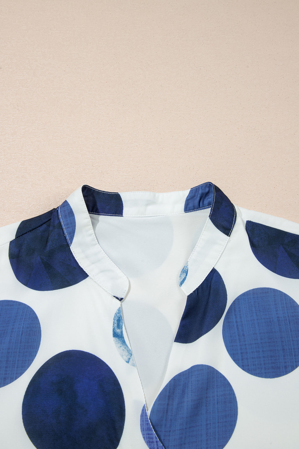 Décolleté en V et boutons de la robe blanche à pois bleu