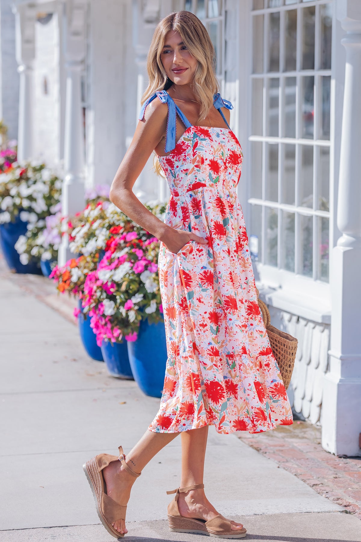 Robe midi imprimé floral rouge, bretelles nouées bleues, coupe ample évasée.