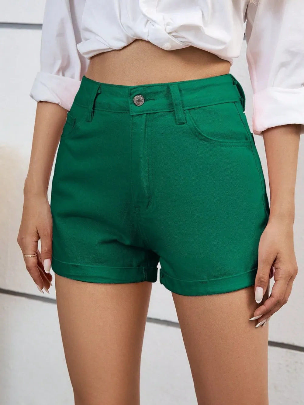 Short taille haute vert avec poches, fermeture à bouton et braguette.