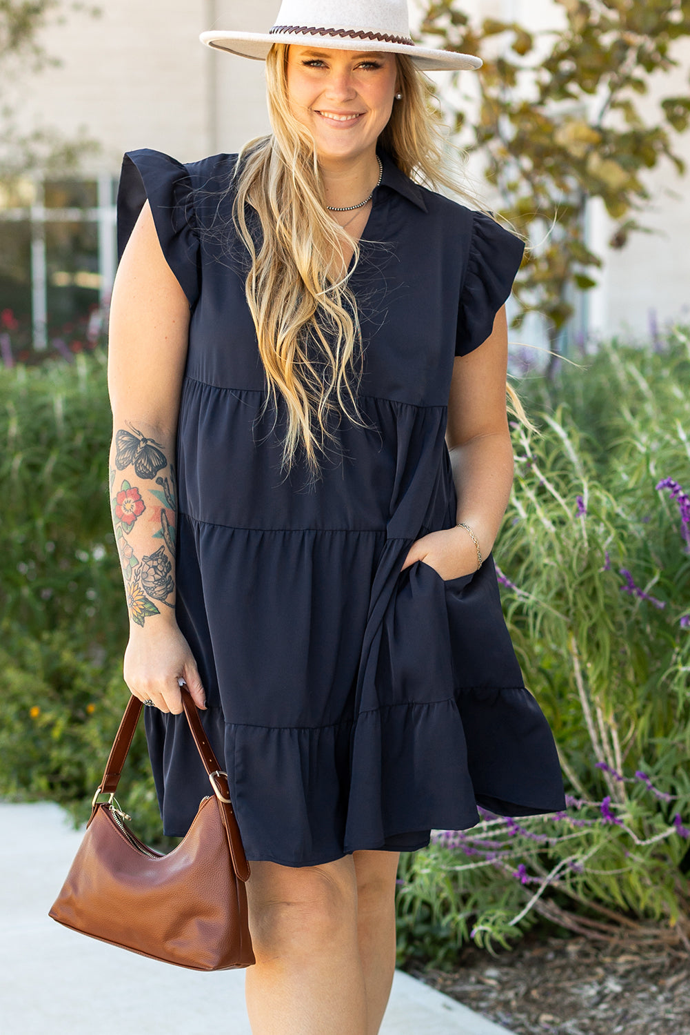 Robe bleue marine à volants, manches volantées, poche latérale discrète.
