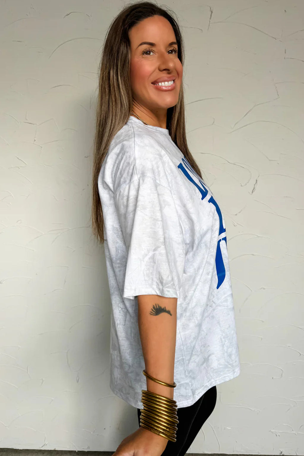 T-shirt gris clair à manches courtes, vue de profil avec imprimé bleu