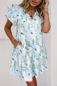 Robe courte blanche à motifs végétaux bleu clair et verts, col V, manches volantées.