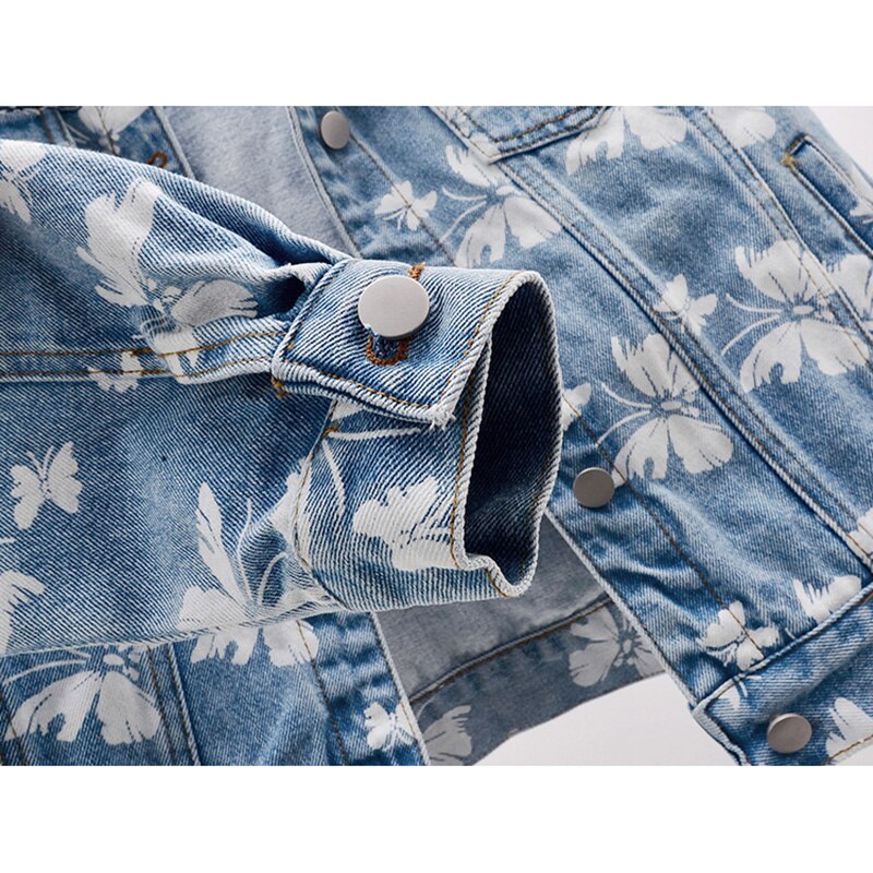 Veste en jean bleue, motif floral blanc, ourlet avec bouton-pression et galon