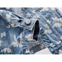 Veste en jean bleue, motif floral blanc, ourlet avec bouton-pression et galon