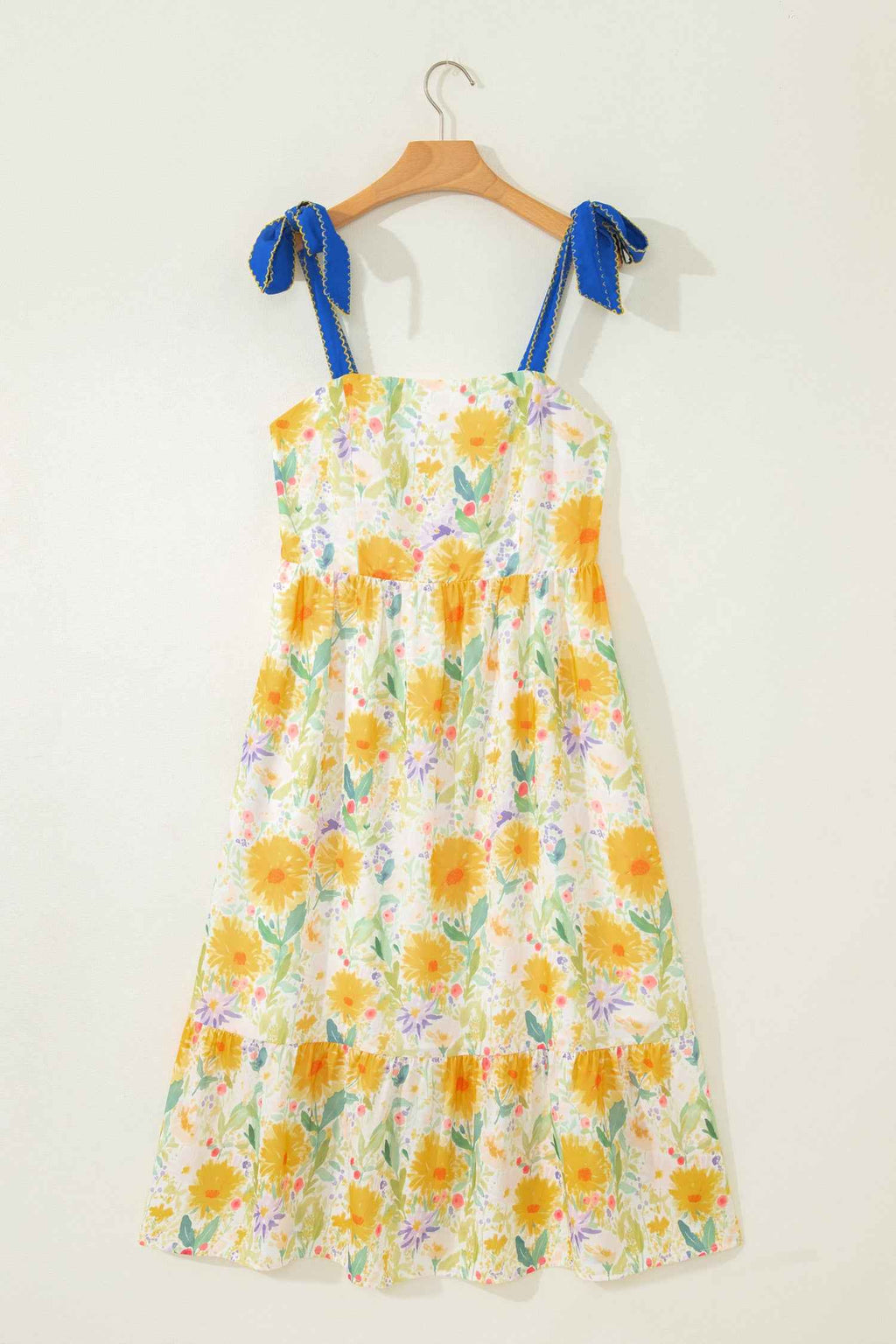 Robe midi imprimé floral jaune, bretelles à nœuds bleus, ourlet volanté, taille haute.