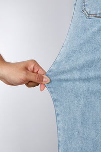Jean bleu ciel en denim : main vérifie la couture au niveau de la jambe.