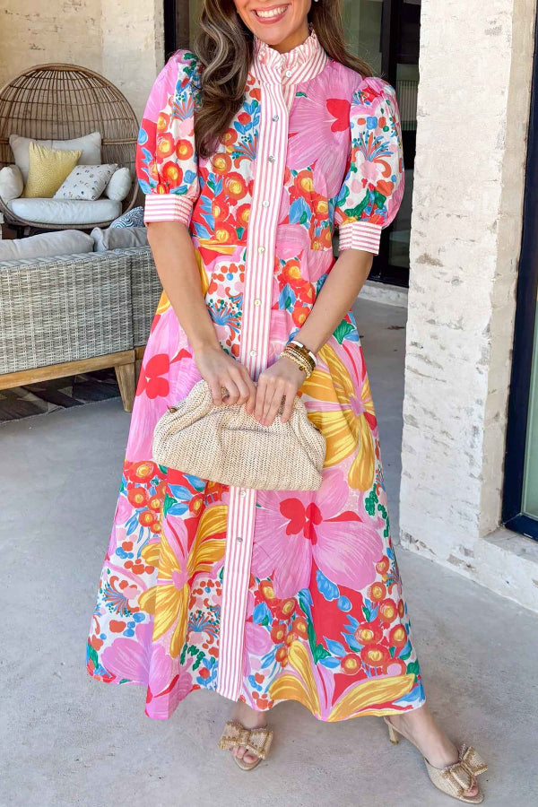 Robe fleurie rose à manches courtes, col montant boutonné, motif floral multicolore.