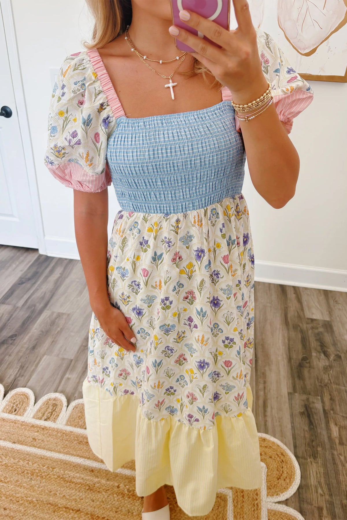 Robe longue fleurie: buste bleu smocké, encolure carrée, manches bouffantes roses.
