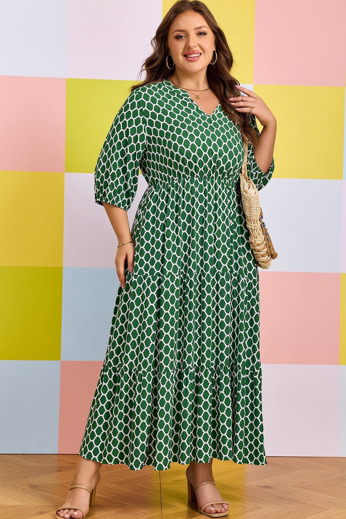 Robe maxi verte à motif géométrique, manches trois-quarts, taille légèrement cintrée.