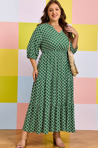 Robe maxi verte à motif géométrique, manches trois-quarts, taille légèrement cintrée.