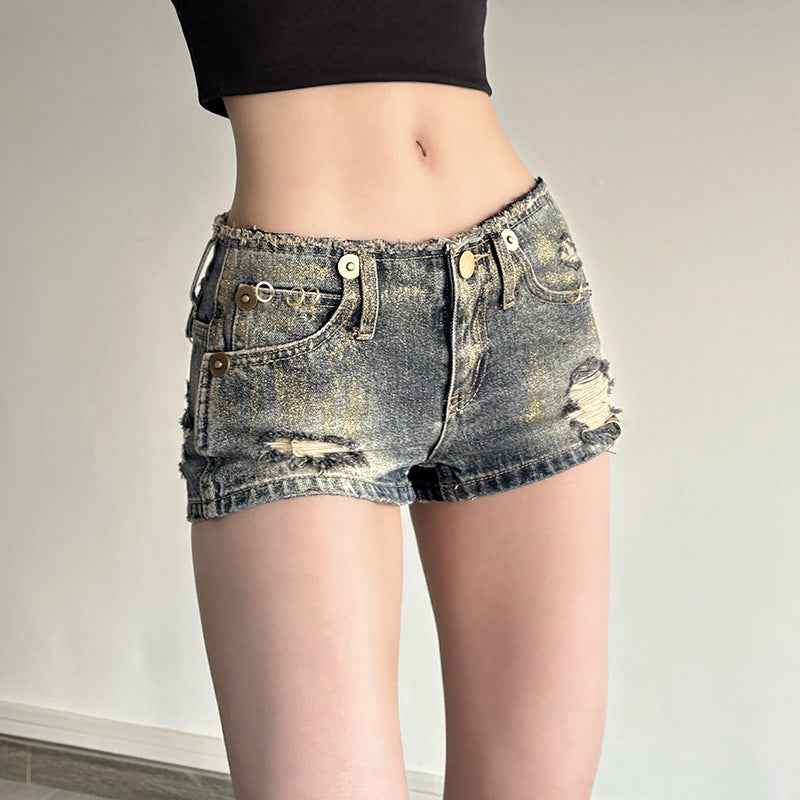 Short en denim bleu vintage pour femme, déchirures latérales, ourlet effiloché.