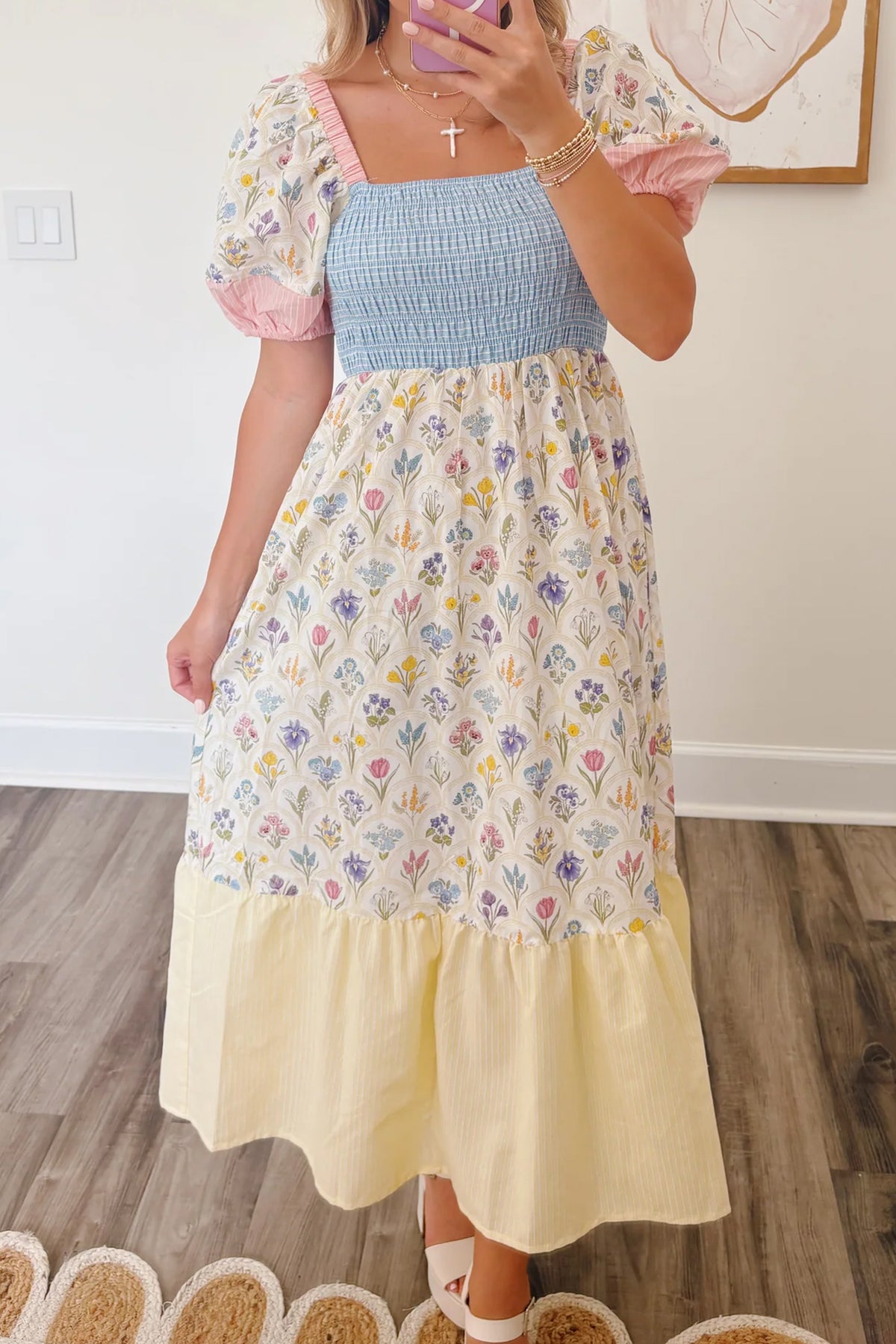 Robe longue: buste bleu smocké, jupe blanche fleurie, volants bas, manches bouffantes roses.