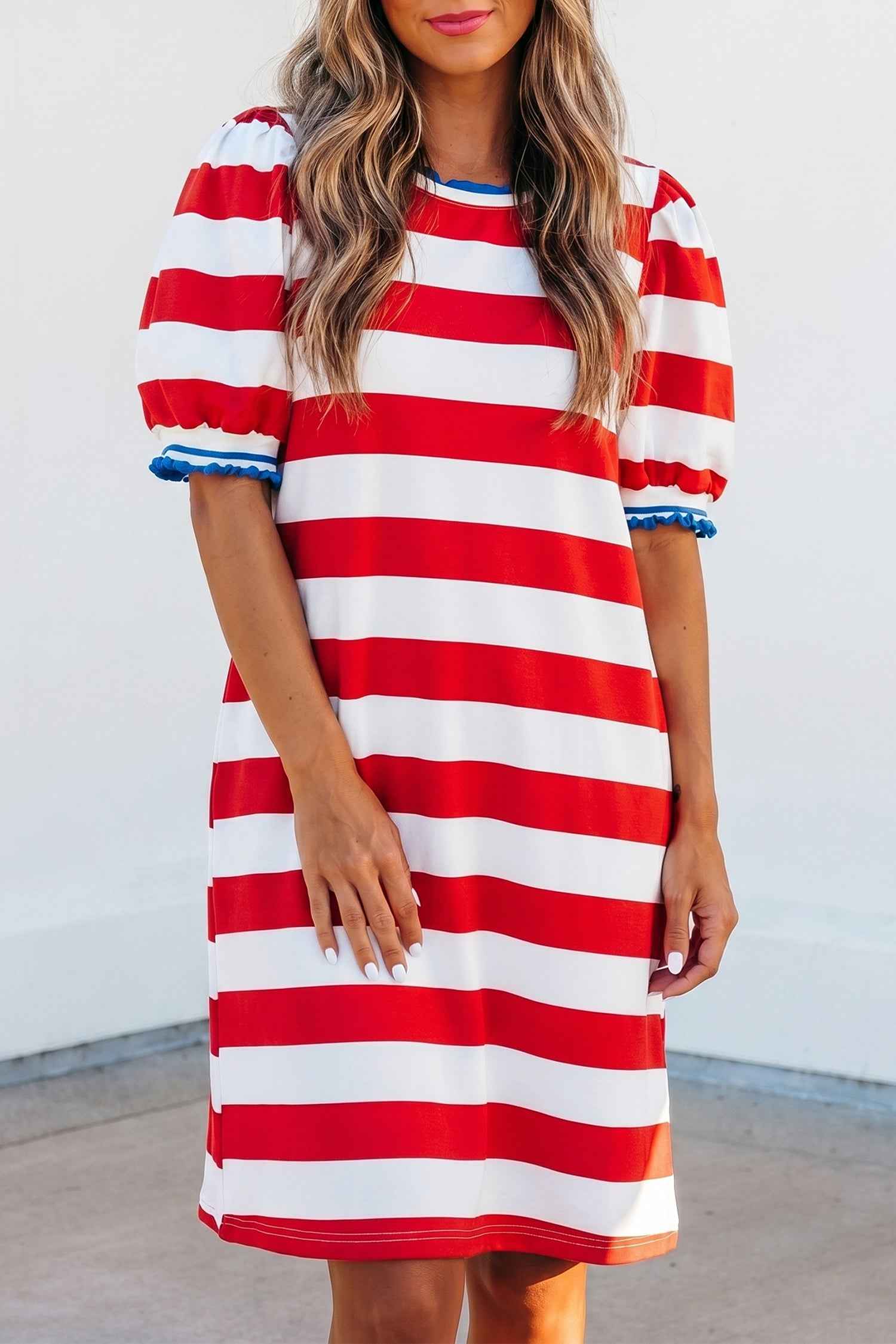 Robe mini rayée rouge et blanche avec bordure contrastée bleue, col rond.