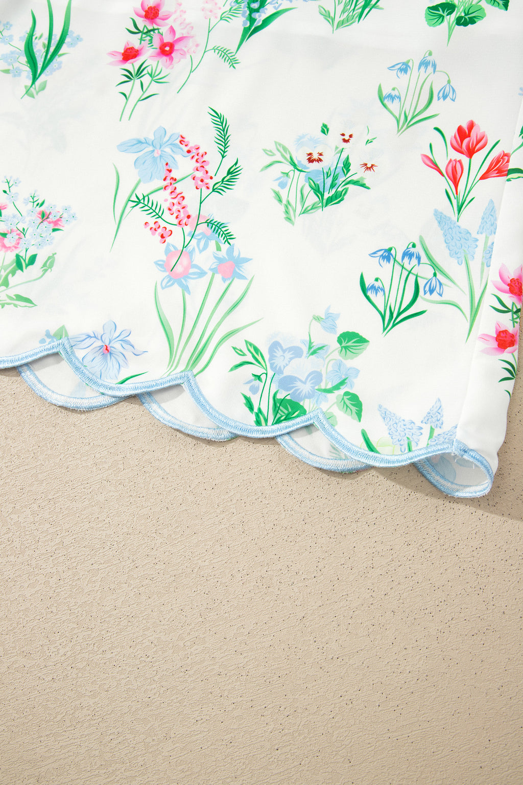 Ourlet festonné de robe, bord bleu clair, imprimé floral sur fond clair