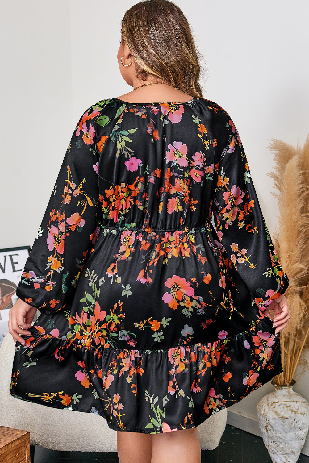 Robe noire fleurie à volants, manches longues, vue de dos.