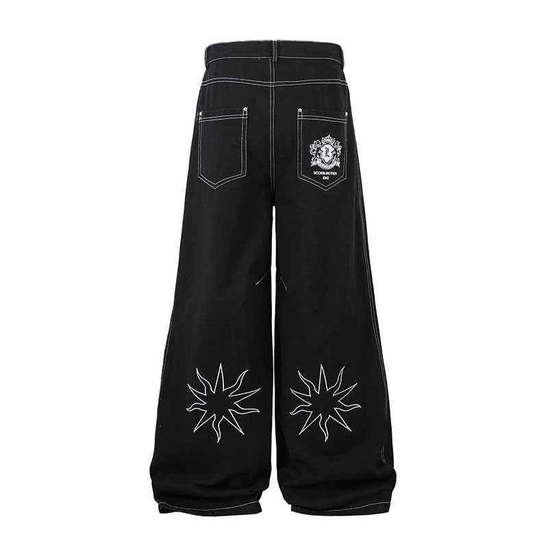 Pantalon jean femme noir à broderies florales, poches arrière et ceinture boutonnée.