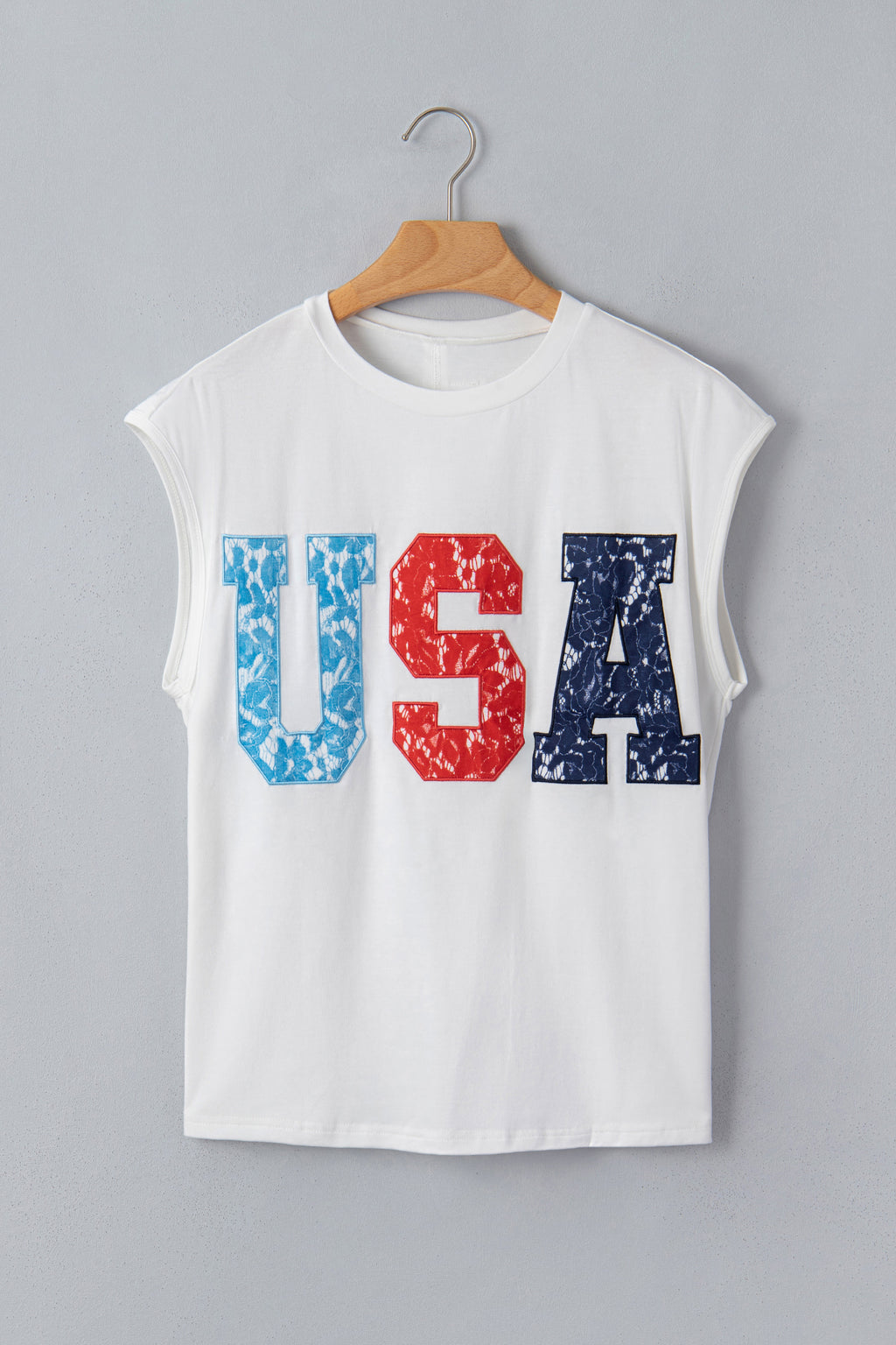 T-shirt dolman blanc pour femme, imprimé USA rouge et bleu, porté sur cintre.