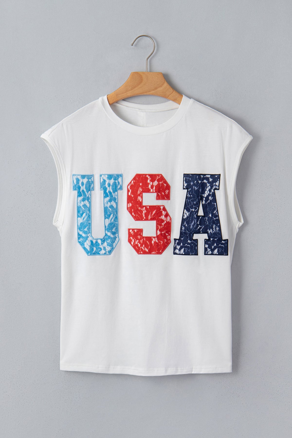 T-shirt dolman blanc pour femme, imprimé USA rouge et bleu, porté sur cintre.
