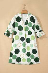 Robe courte blanche à pois verts, manches trois-quarts, encolure boutonnée