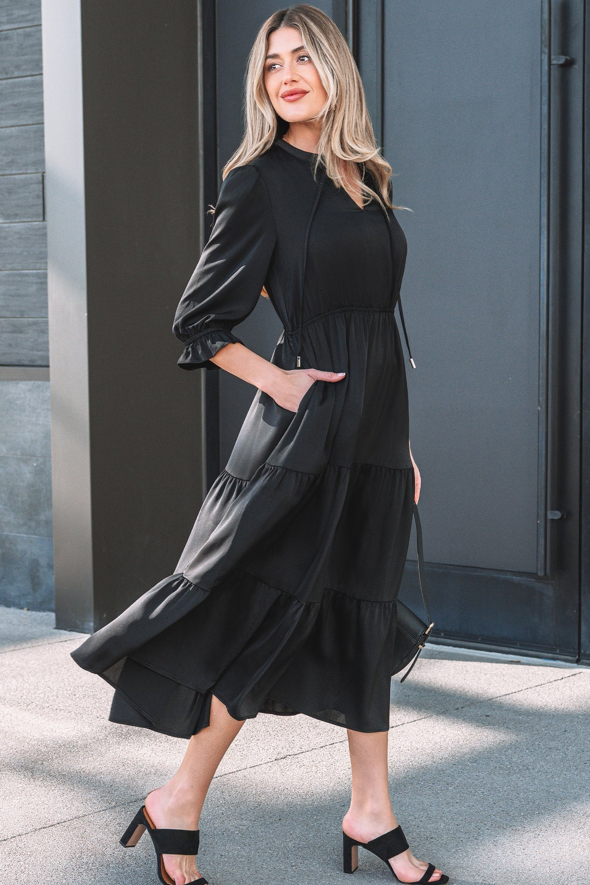 Robe maxi noire à volants étagés, col V, manches 3/4, ourlet évasé.