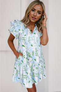 Robe courte blanche à motifs végétaux bleu clair et verts, manches volantées, col V.