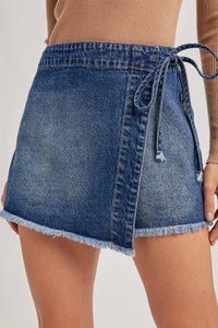 Short en jean bleu avec ceinture nouée sur le côté et ourlet effiloché