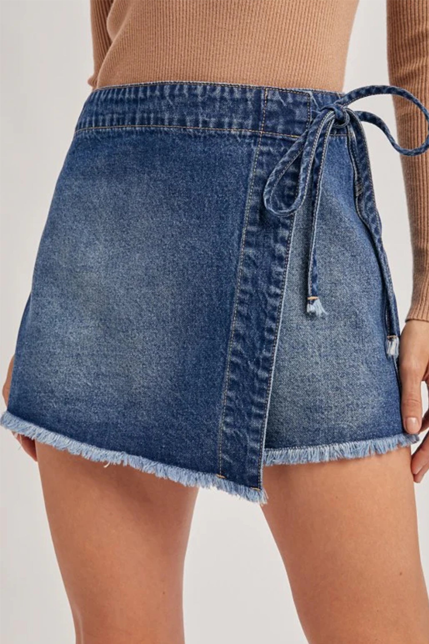 Short en jean bleu avec ceinture nouée sur le côté et ourlet effiloché