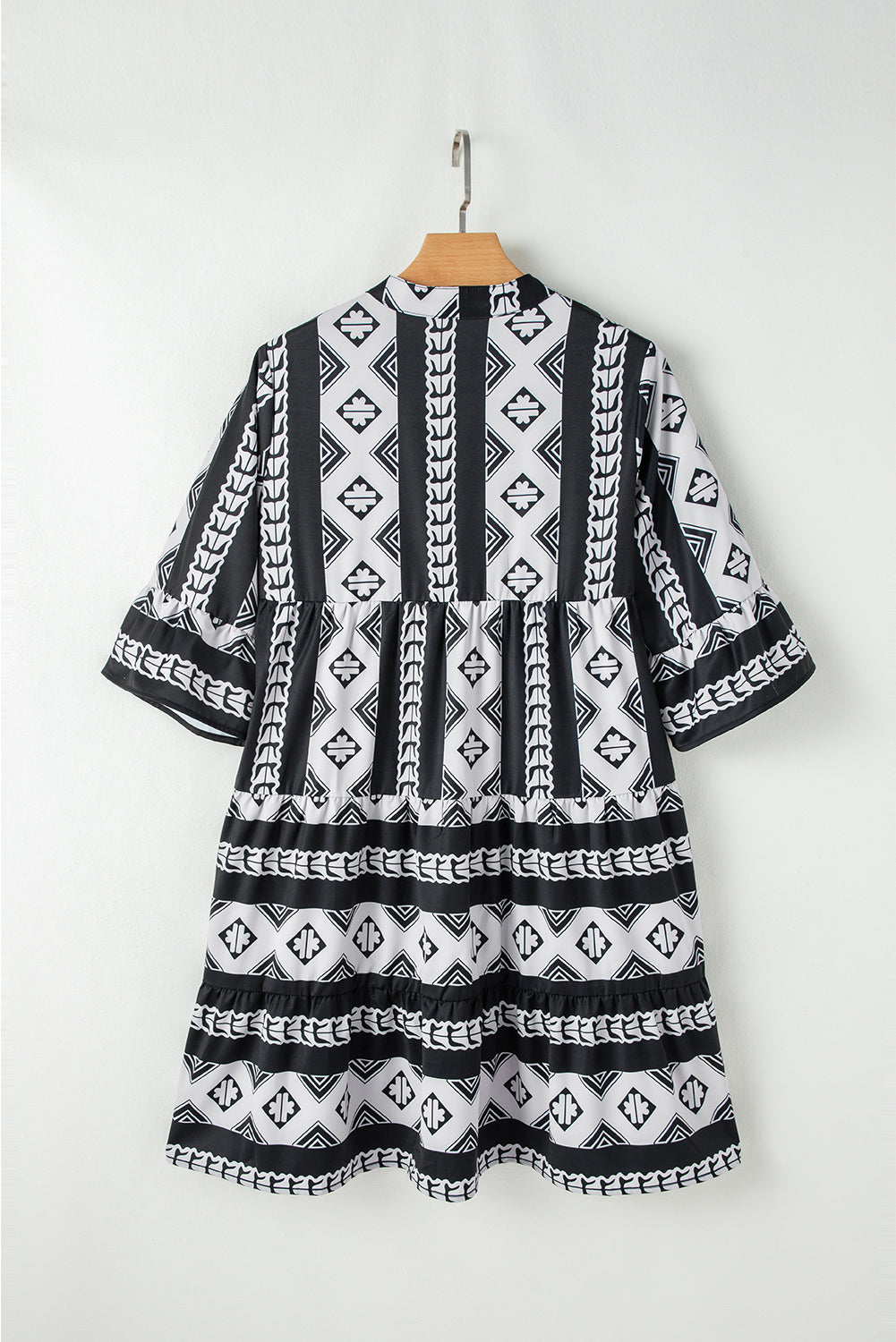 Robe noire à motifs géométriques, dos, manches évasées à volants