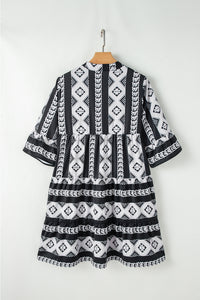 Robe noire à motifs géométriques, dos, manches évasées à volants