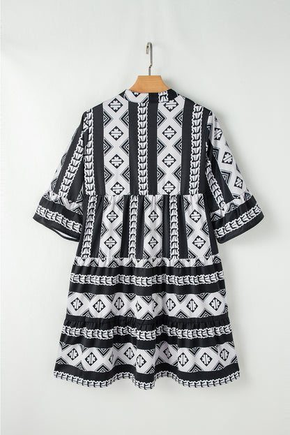 Robe noire imprimé géométrique col V manches à volants femmvue de dos sur un cintre