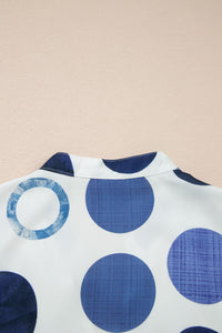 Gros plan sur encolure de la robe blanche à pois bleu