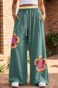 Pantalon ample vert mer à fleurs appliquées, taille élastique et cordon, poches latérales.