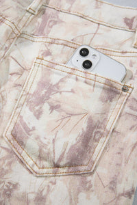 Jean large femme motif camouflage rose clair, poche avant et surpiqûres visibles.