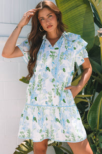 Robe courte blanche à motifs végétaux bleu clair et verts, manches volantées, col V.