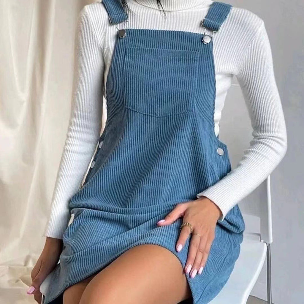 Robe sans manches en velours côtelé bleu, bretelles boutonnées, poche sur le devant.