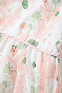 Robe courte rose à fleurs, motif feuillages vert et ruban à rayures sur l’encolure.
