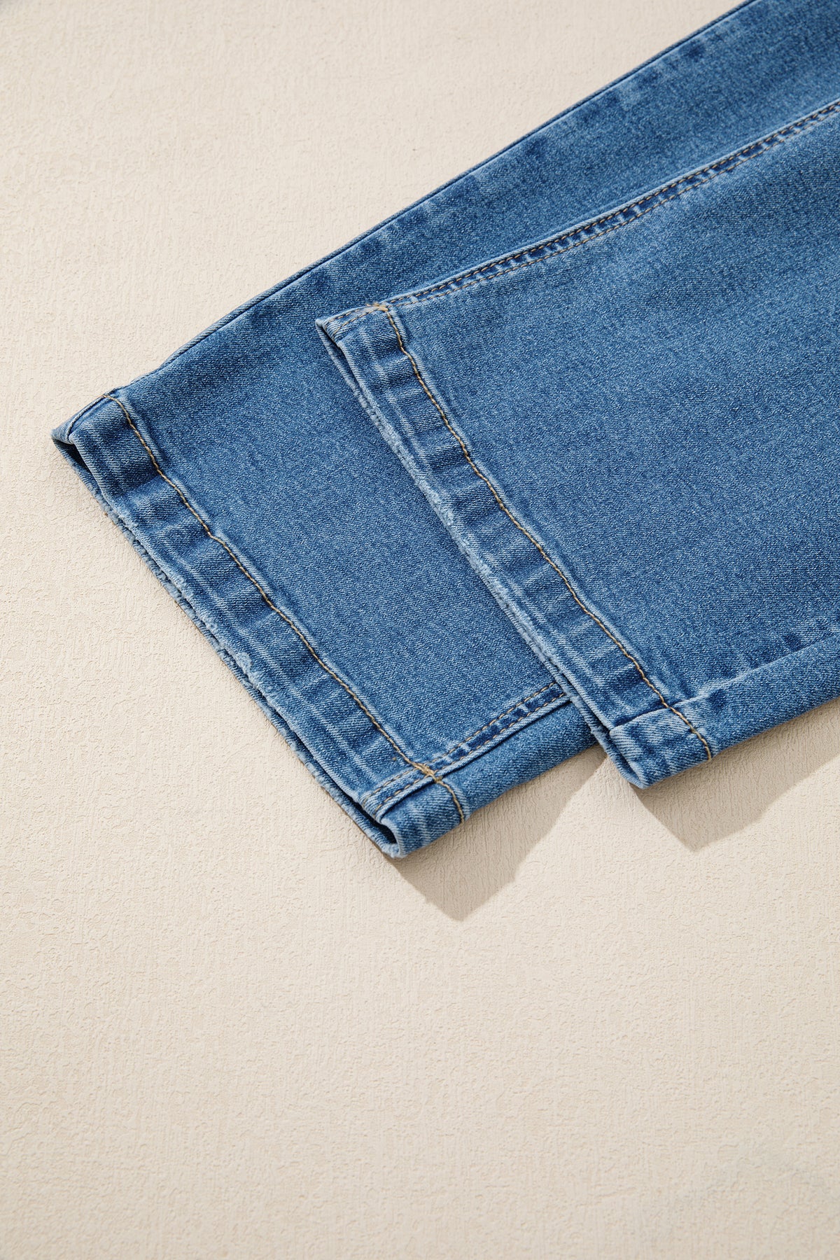 Bas de jean bleu myosotis, ourlet simple avec tissu délavé.