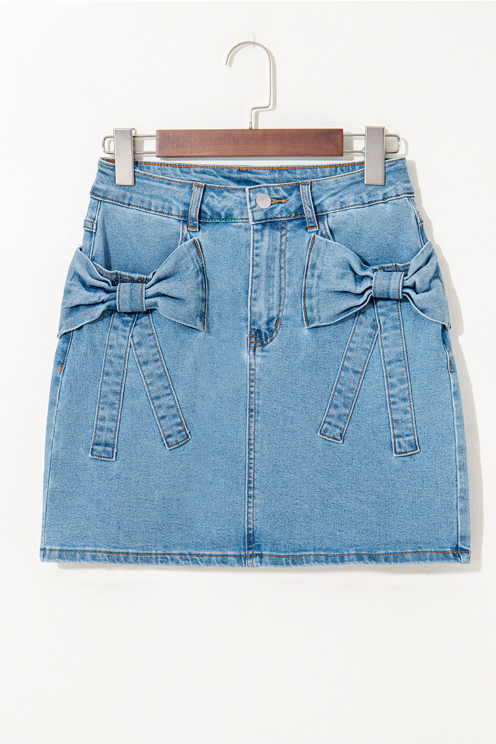 Jupe en jean bleu clair taille haute, nœuds devant, vue de face sur cintre