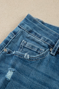 Détail ceinture jean flare taille haute bleu moyen, passants et bouton de fermeture.